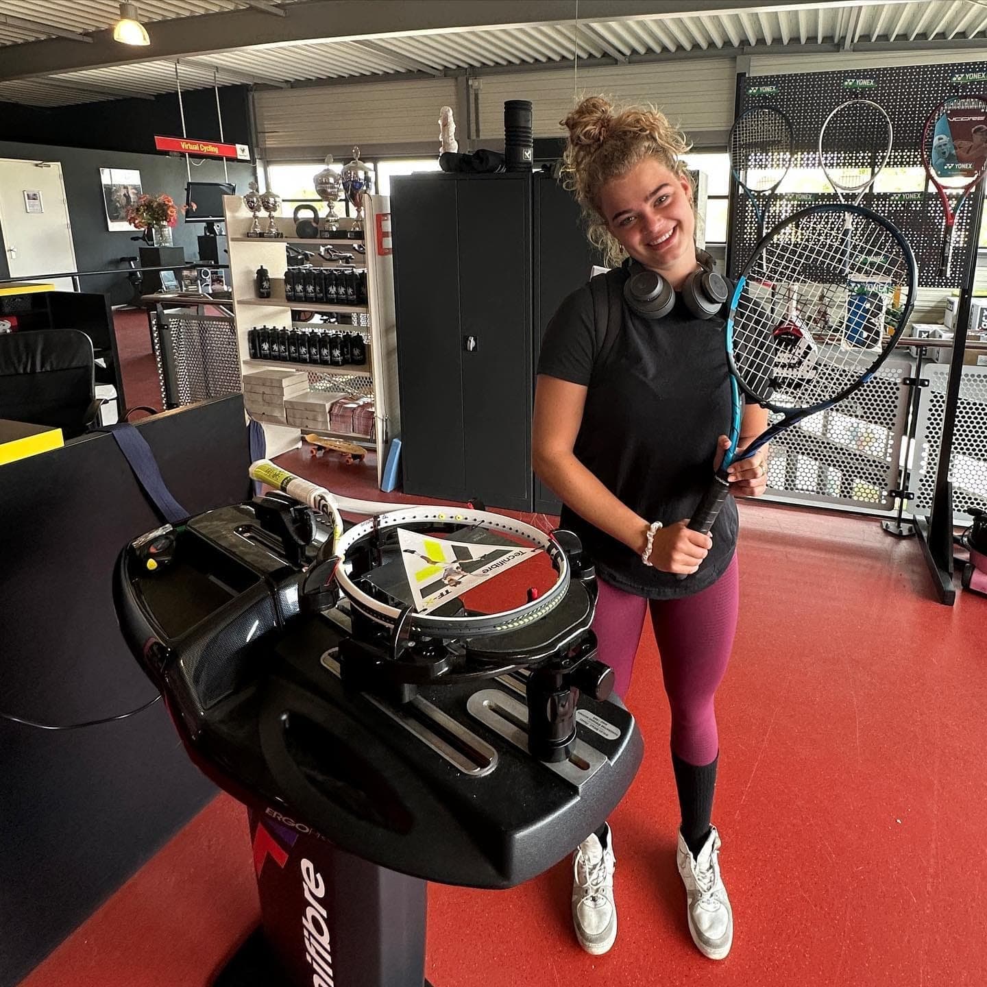 Tevreden klant met haar racket in de werkplaats van Bespannen.nl